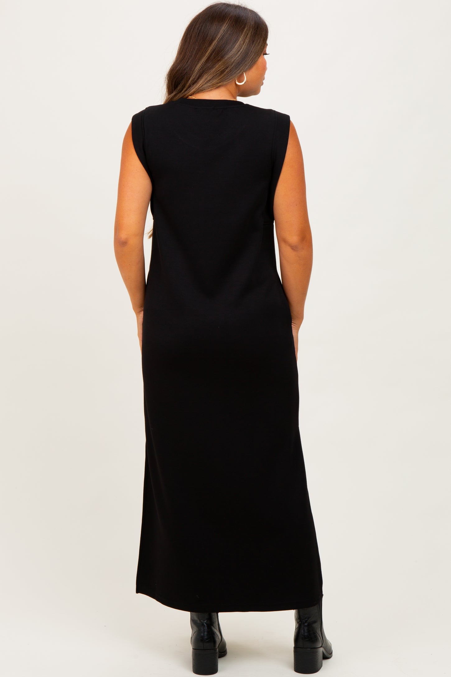 woman wearing a long black sleeveless maternity dress, seen from the back