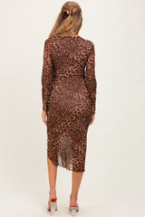 woman wearing a brown leopard print maternity dress with a fitted silhouette and long sleeves, showing her baby bump