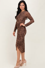 woman wearing a brown leopard print long sleeve dress with ruching details and a high-low hem, paired with beige high heels