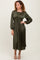 woman wearing an olive green pleated midi dress with long sleeves and a cinched waist, standing and posing