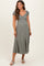 woman wearing a dusty green maternity maxi dress with puff sleeves and button detail, showcasing a visible baby bump