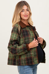 woman wearing a green and brown plaid maternity jacket with a brown collar and elastic cuffs, and showcasing her baby bump