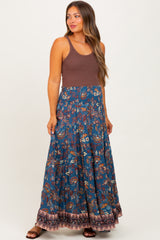 woman wearing a brown tank top and a blue floral maternity maxi skirt with a flowing bottom and a decorative hem
