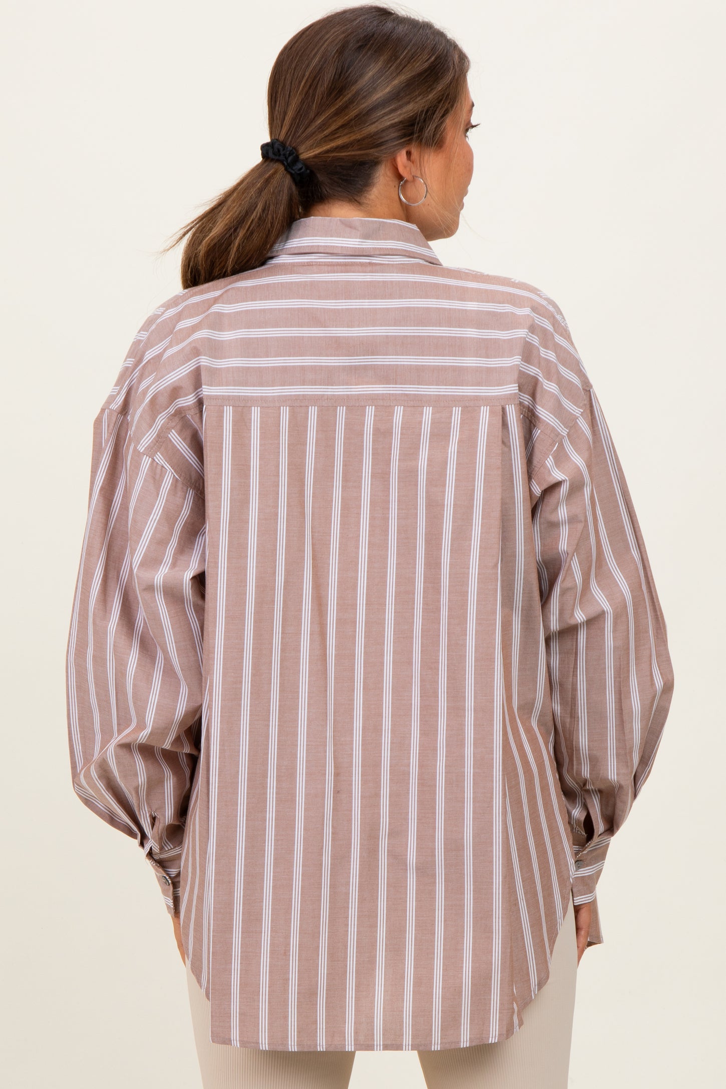 woman wearing a striped maternity shirt with oversized sleeves and a relaxed fit, showing the back view