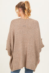 woman wearing a cozy oversized beige maternity sweater with batwing sleeves, viewed from the back