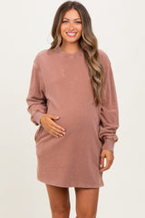 woman wearing a dusty rose oversized maternity sweatshirt dress and holding her baby bump