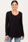 woman wearing a black long sleeve top with a rounded neckline and smiling