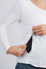 woman showing a white long sleeve maternity top with discreet nursing access openings