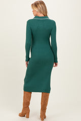 woman wearing a dark green ribbed maternity dress with a fitted silhouette and long sleeves