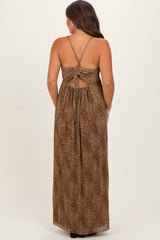 woman wearing a brown leopard print maternity maxi dress with a cutout back and adjustable straps