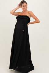 woman wearing a black strapless pleated maternity dress with ruffle detailing and a visible baby bump