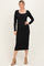 woman wearing a black long sleeve midi dress with a scoop neckline and tan heeled boots