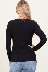 woman wearing a black ribbed long sleeve sweater with a fitted silhouette, shown from the back