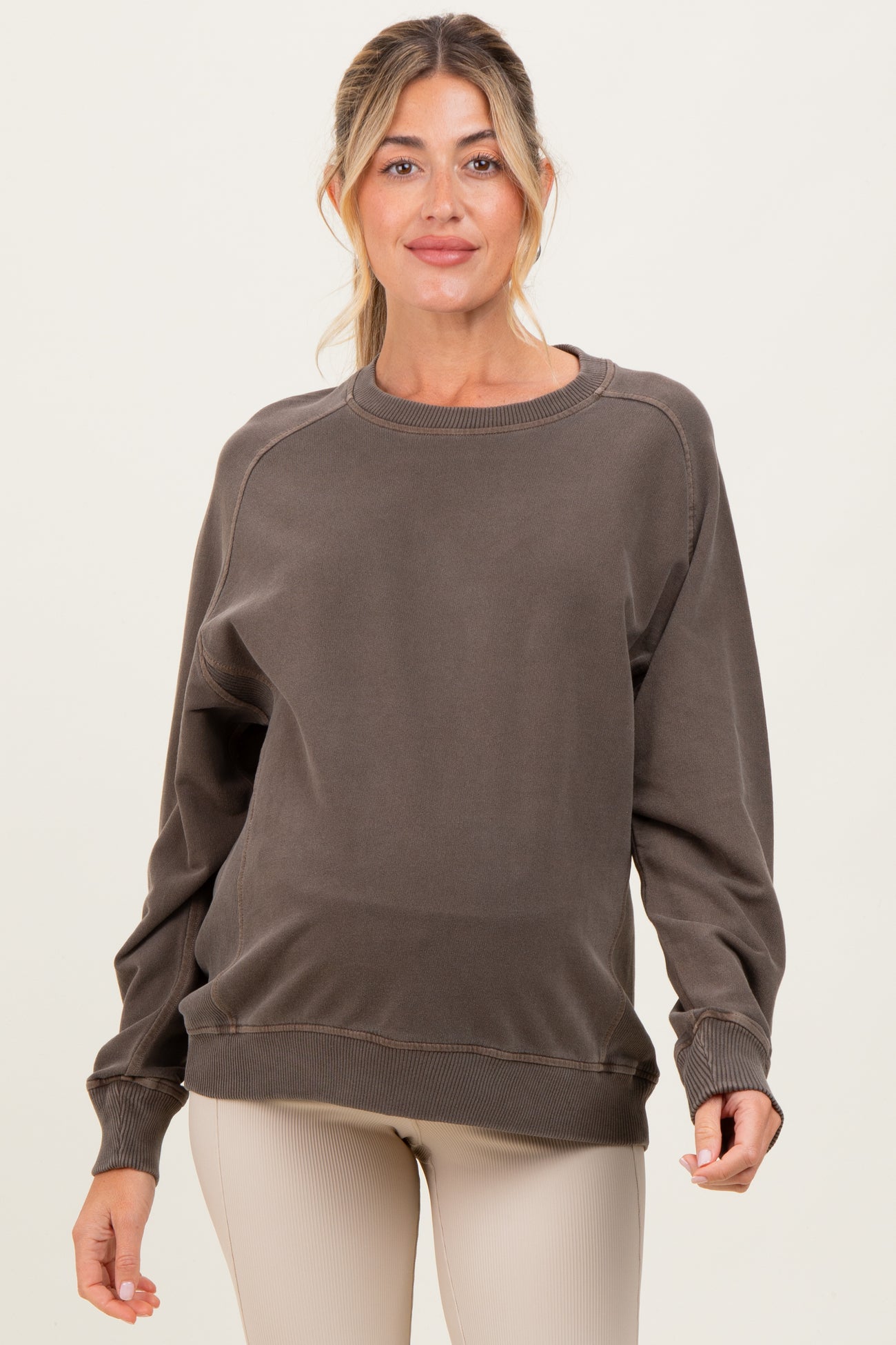 woman wearing a brown maternity sweatshirt with long sleeves and relaxed fit, showcasing a baby bump