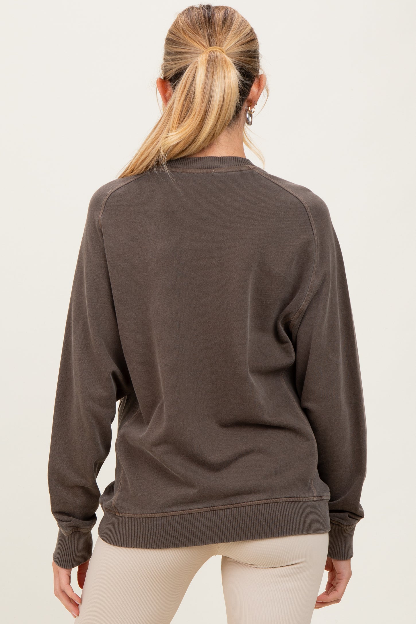 woman wearing a dark brown maternity sweatshirt with a relaxed fit, seen from the back