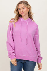 woman wearing a light purple oversized hoodie with drawstrings and ribbed hem, paired with blue jeans