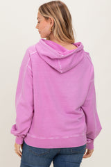 woman wearing a pink hooded sweatshirt with a relaxed fit and ribbed hem, viewed from the back