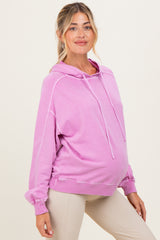 woman wearing a pink oversized maternity hoodie with a drawstring and visible baby bump