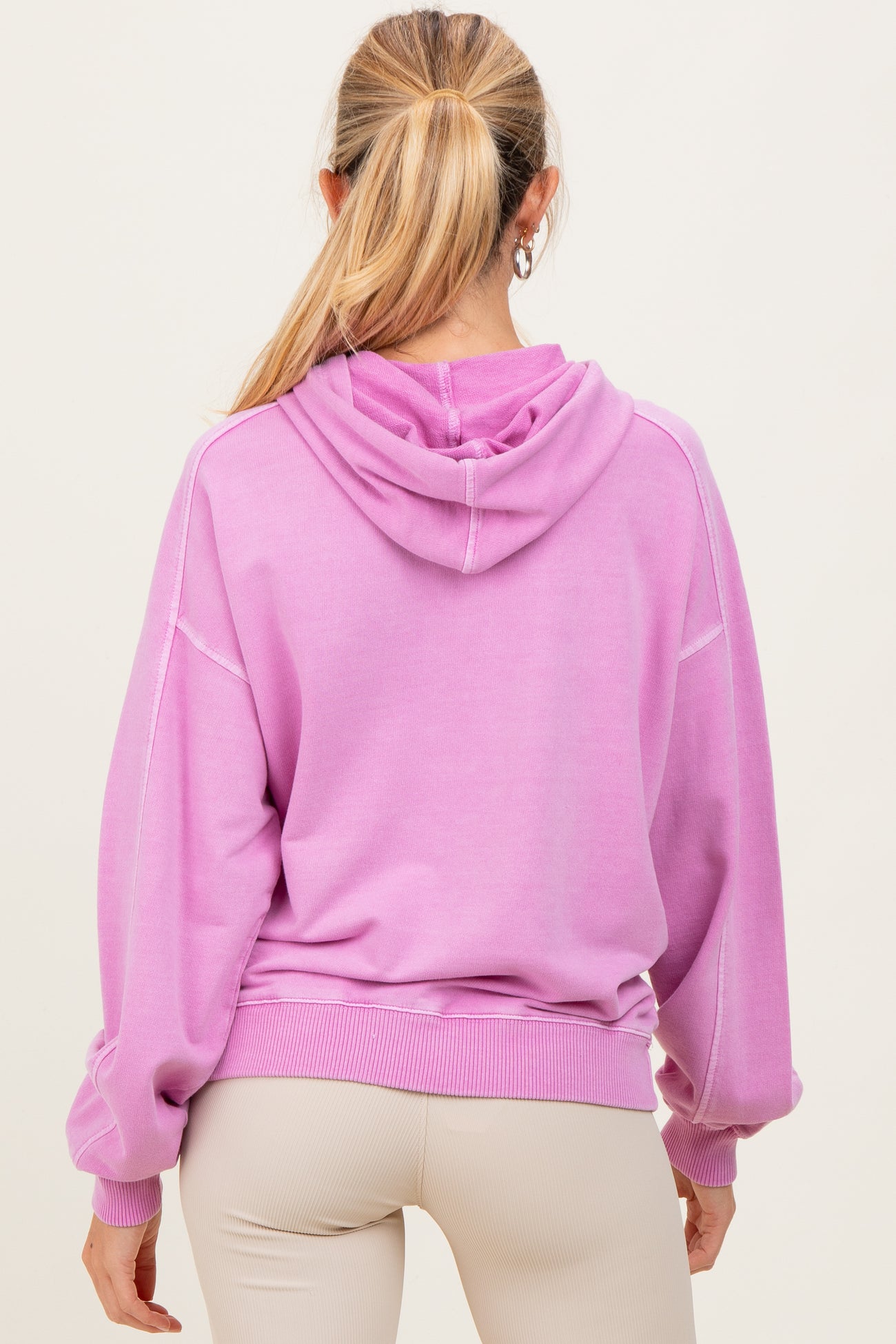 woman wearing a purple oversized maternity hoodie with a hood and balloon sleeves, viewed from the back
