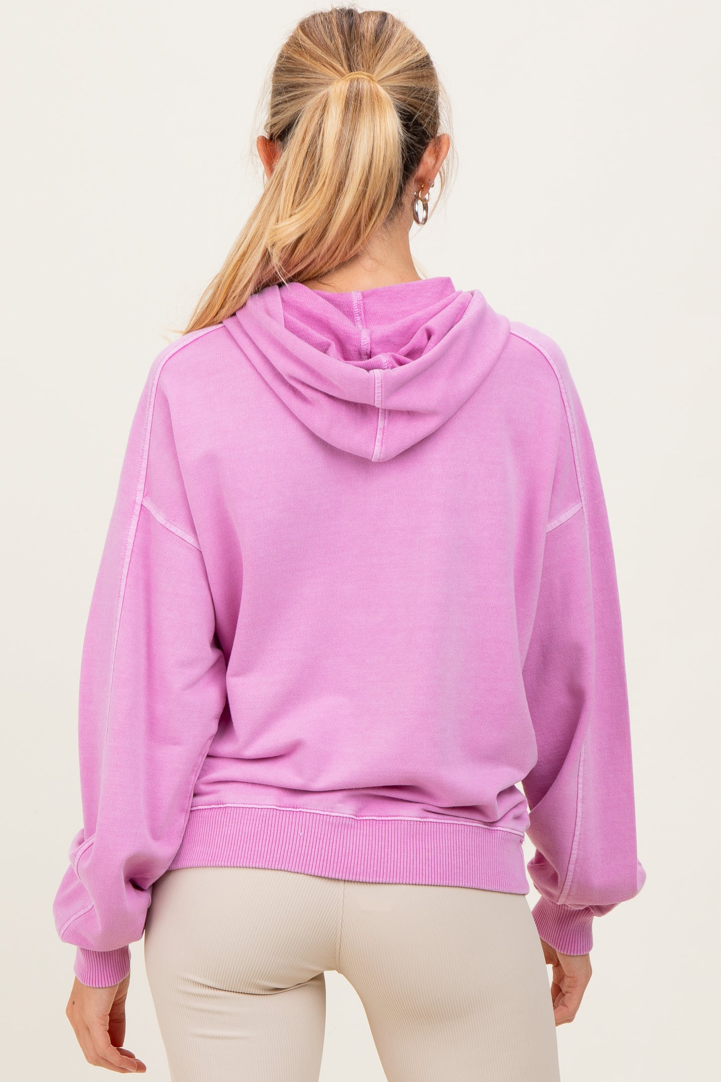 woman wearing a purple oversized maternity hoodie with a hood and balloon sleeves, viewed from the back