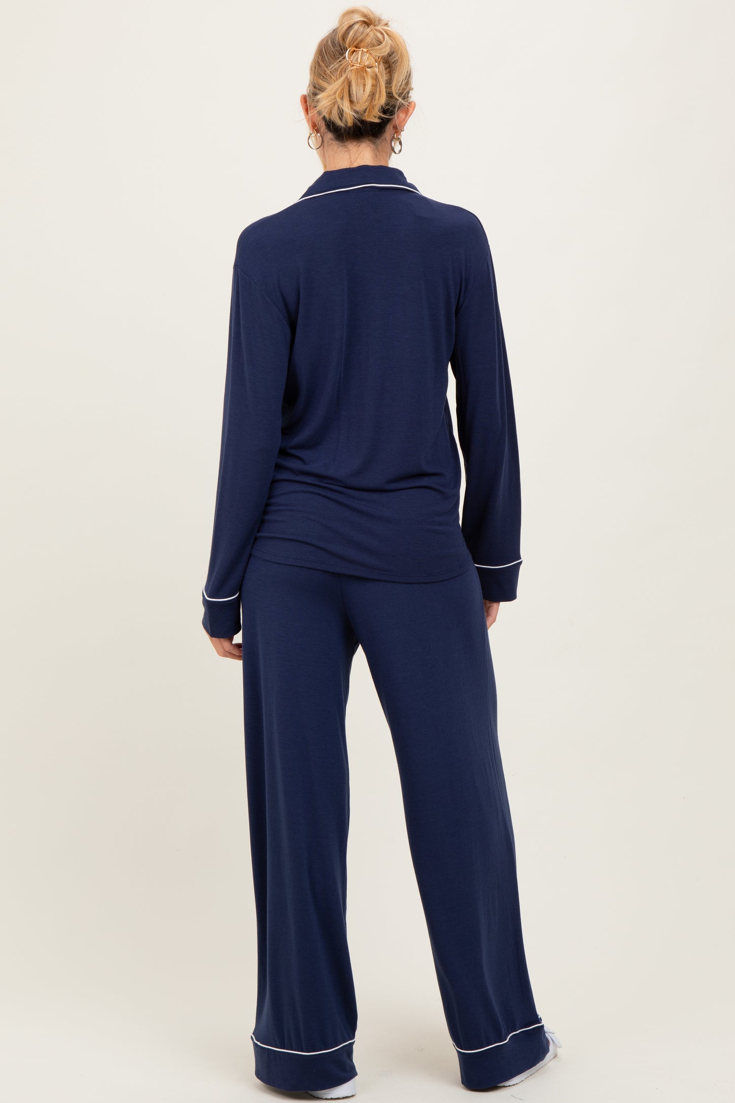 woman wearing a navy blue maternity pajama set with long sleeves and wide-leg pants, showing a relaxed fit