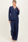 woman wearing a navy blue long sleeve pajama set with white piping and wide-leg pants