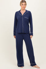 woman wearing a navy blue long sleeve pajama set with white piping details and relaxed fit pants