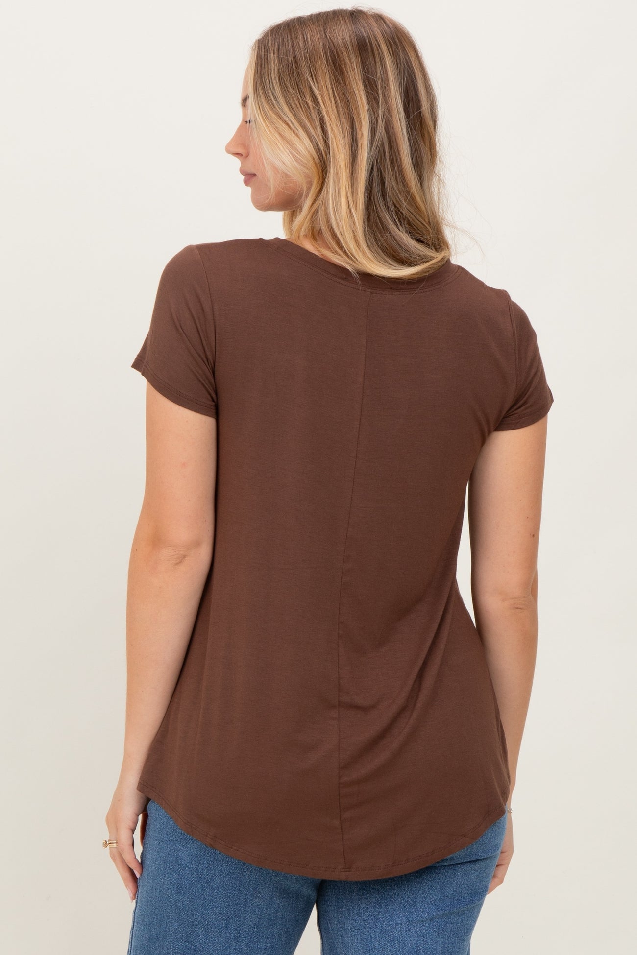 woman wearing a brown short sleeve top with a curved hemline and back seam detail