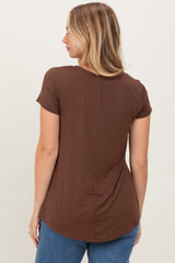 woman wearing a brown short sleeve top with a curved hemline and back seam detail
