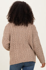 woman wearing a cozy beige cable knit sweater with a relaxed fit and long sleeves, viewed from the back