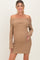 woman wearing a brown off-the-shoulder maternity dress, posing with her baby bump visible