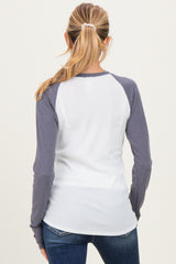 woman wearing a white and gray long sleeve maternity top viewed from the back