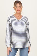 woman wearing a striped maternity sweater with a v-neckline and long sleeves, paired with blue jeans