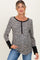 woman wearing a black and white leopard print maternity top with button details and long sleeves, showing her baby bump