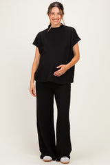 woman wearing a black ribbed maternity loungewear set with a visible baby bump