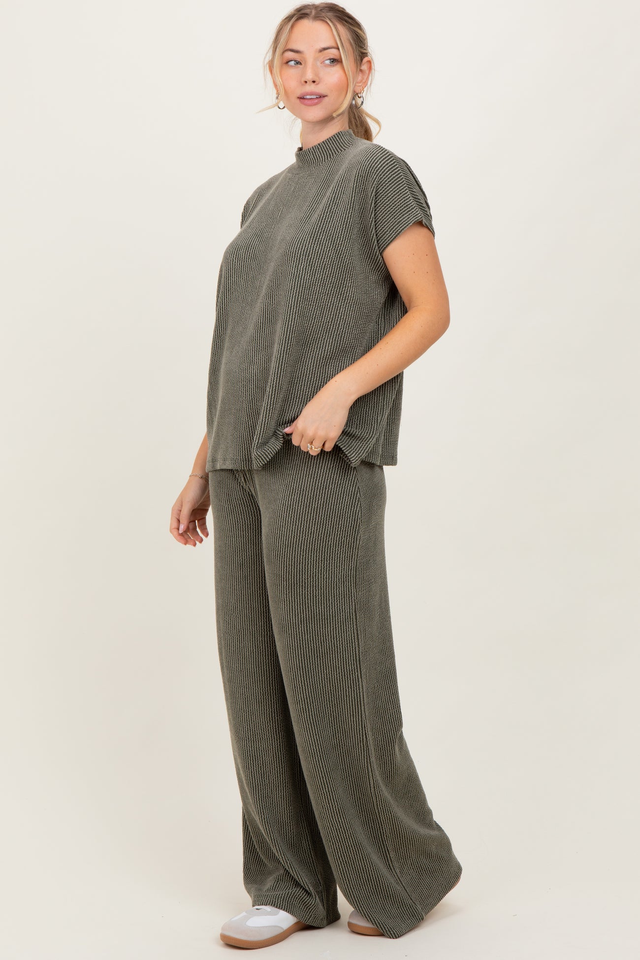woman wearing a green ribbed matching set consisting of a short sleeve top and wide leg pants