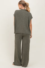 woman wearing a sage green striped two-piece lounge set with short sleeves and wide-leg pants