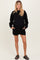 woman wearing black maternity sweatshirt and matching shorts, with pockets and a relaxed fit