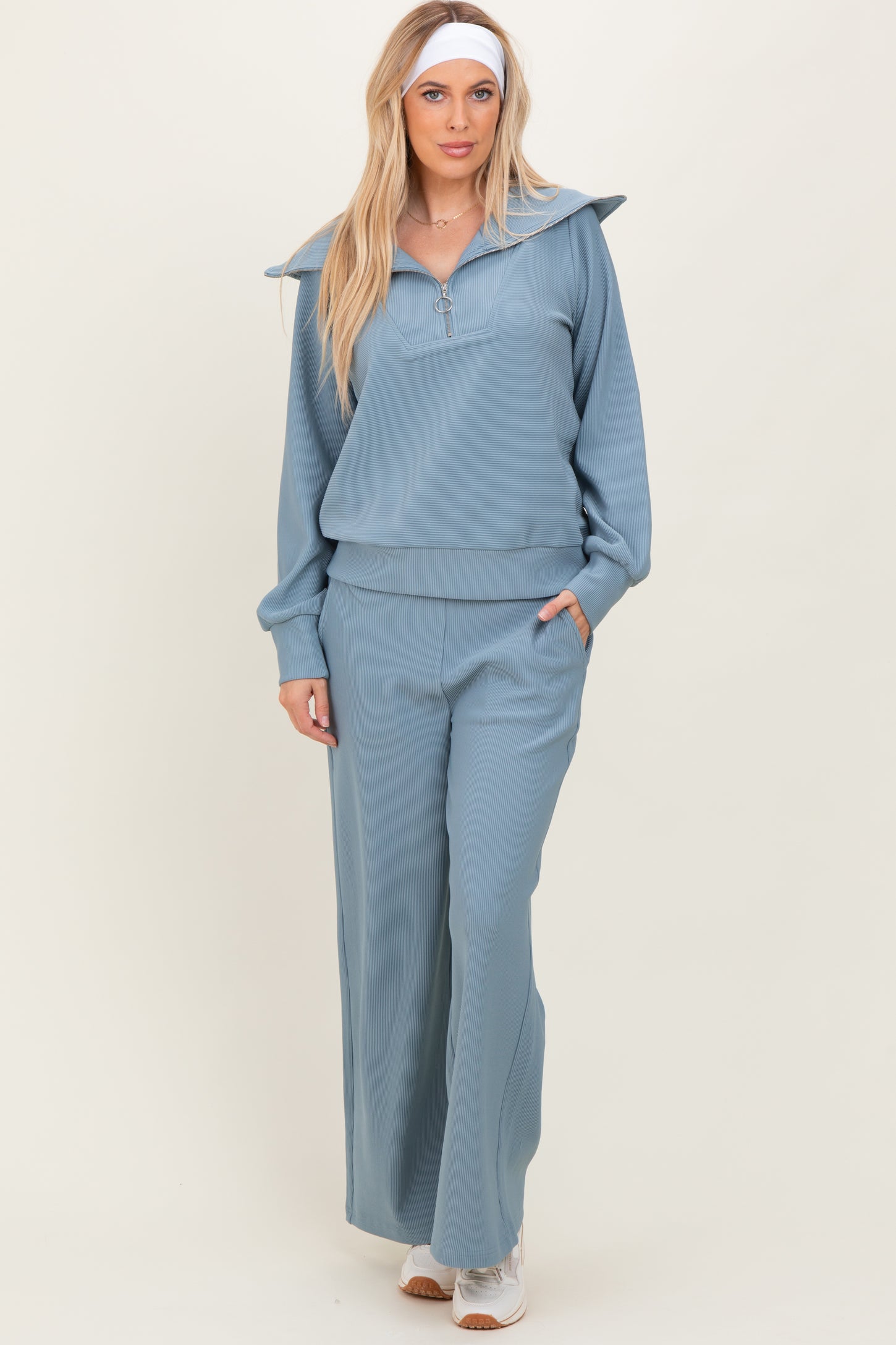 woman wearing a light blue ribbed matching set with a collared long sleeve top and wide-leg pants