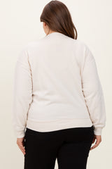 woman wearing a light beige maternity sweatshirt, seen from the back, with relaxed fit and cuffed sleeves