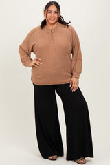 woman wearing a tan oversized sweater with buttons and black wide-leg pants