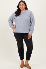 woman wearing a gray oversized sweater and black jeans with brown slip-on shoes