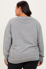 woman wearing a grey long sleeve plus size sweatshirt with a crew neck and ribbed hem, seen from the back