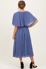 woman wearing a pleated blue midi dress with cape sleeves and button details at the back