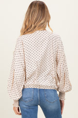 woman wearing a polka dot maternity top with balloon sleeves and gathered hem, featuring a relaxed fit