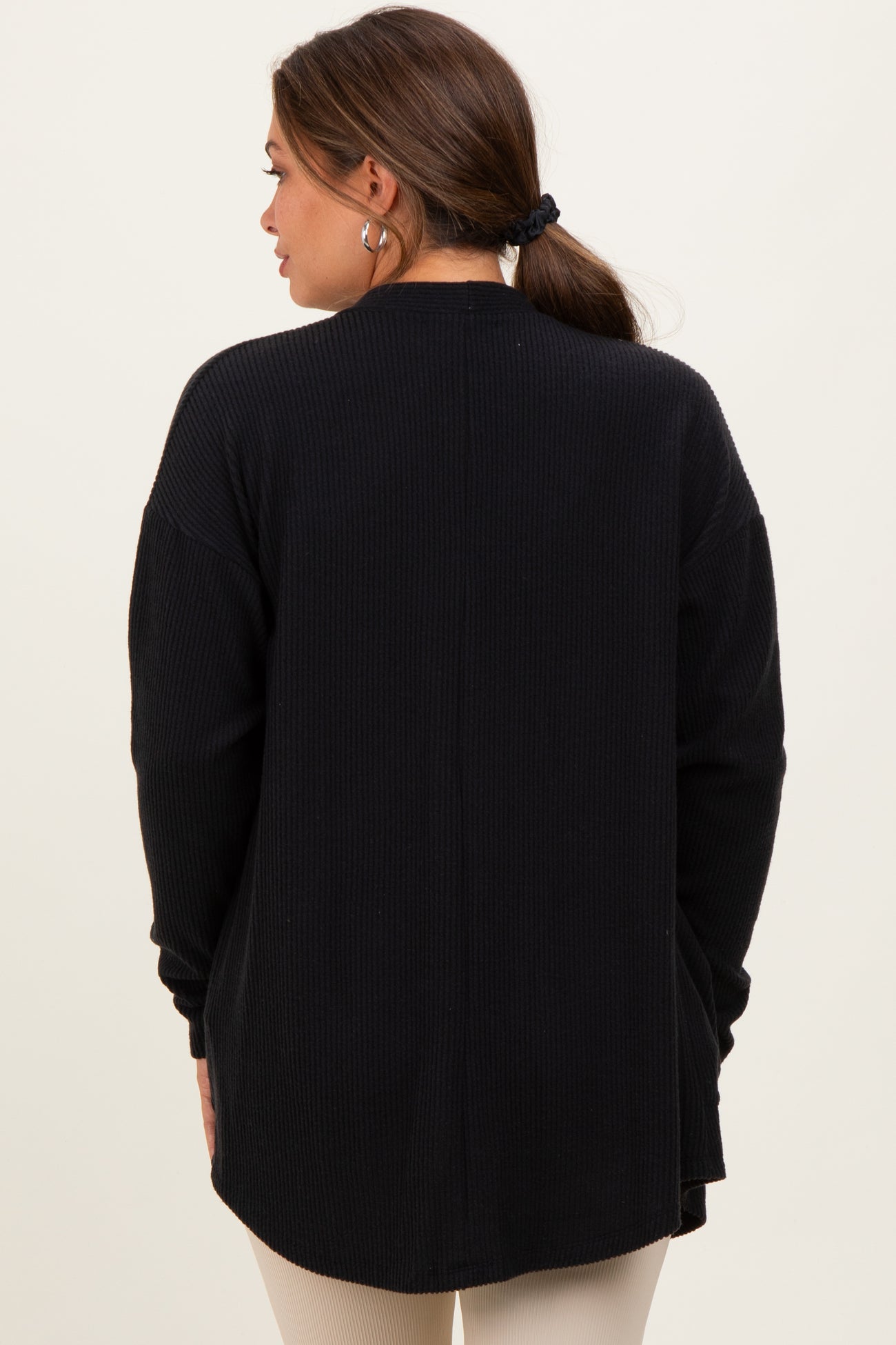 woman wearing a black maternity cardigan with a ribbed texture, shown from the back