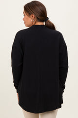 woman wearing a black maternity cardigan with a ribbed texture, shown from the back