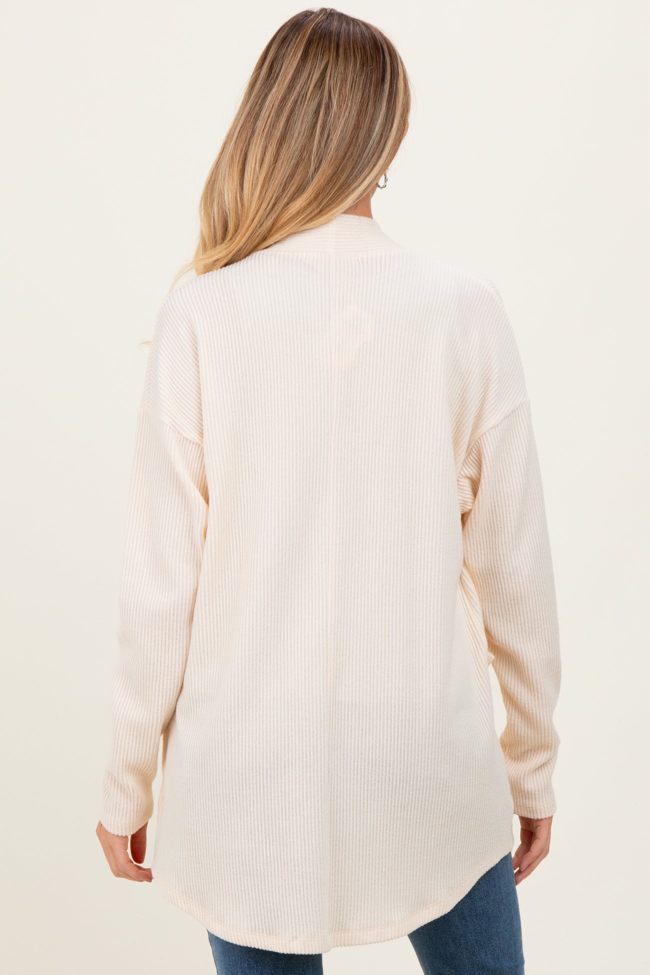 woman wearing a light beige long sleeve maternity top with a relaxed fit and ribbed texture, seen from the back