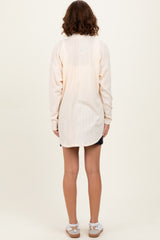woman wearing a light cream long sleeve ribbed tunic with a relaxed fit, shown from the back