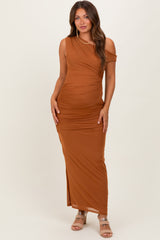 woman wearing a rust colored one shoulder maternity dress with ruching and a side slit, showcasing her baby bump